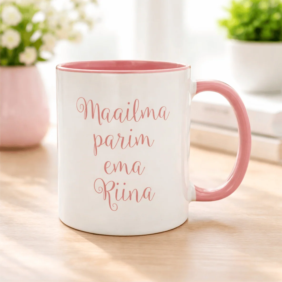 Valge ja roosa kruus, millel on tekst "Maailma parim ema Rina".